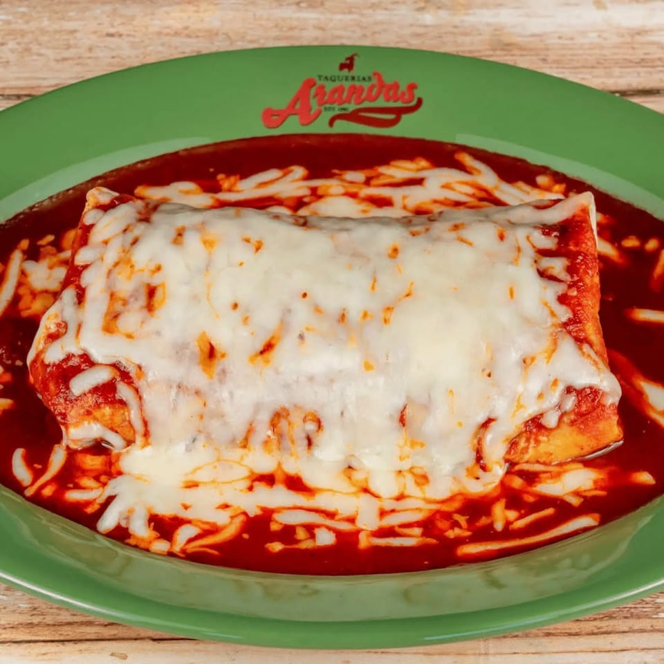 Cheesy enchilada covered in melted cheese and red sauce on a green Taquerias Aguacates plate.