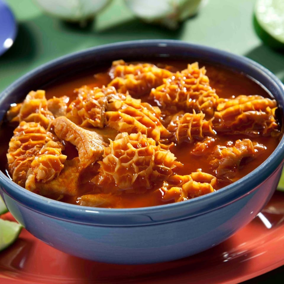 A bowl of textured honeycomb tripe simmered in a rich red sauce.